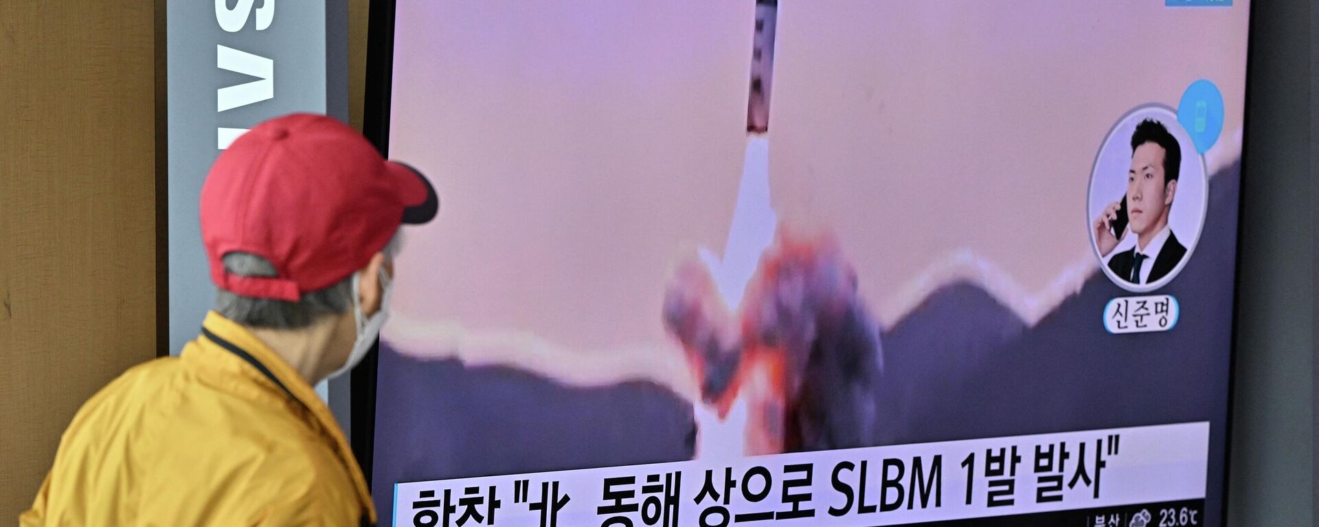 Espetador observa tela televisiva mostrando lançamento de míssil balístico lançado pela Coreia do Norte, em estação ferroviária de Seul, Coreia do Sul, 7 de maio de 2022 - Sputnik Brasil, 1920, 08.05.2022