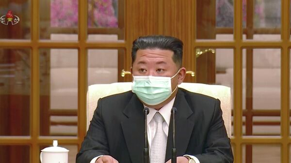O presidente norte-coreano, Kim Jong-un, usa máscara de proteção durante encontro, após a descoberta de um surto de COVID-19 na capital da Coreia do Norte, Pyongyang, 12 de maio de 2022 - Sputnik Brasil