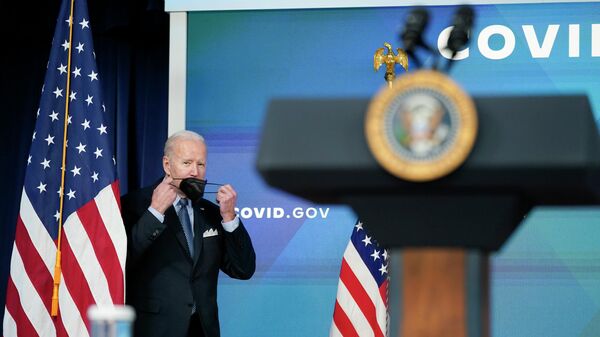 O presidente dos Estados Unidos, Joe Biden, segura sua máscara enquanto se aproxima do púlpito para discursar sobre os esforços do governo no combate à pandemia de COVID-19, em Washington, 30 de março de 2022 - Sputnik Brasil