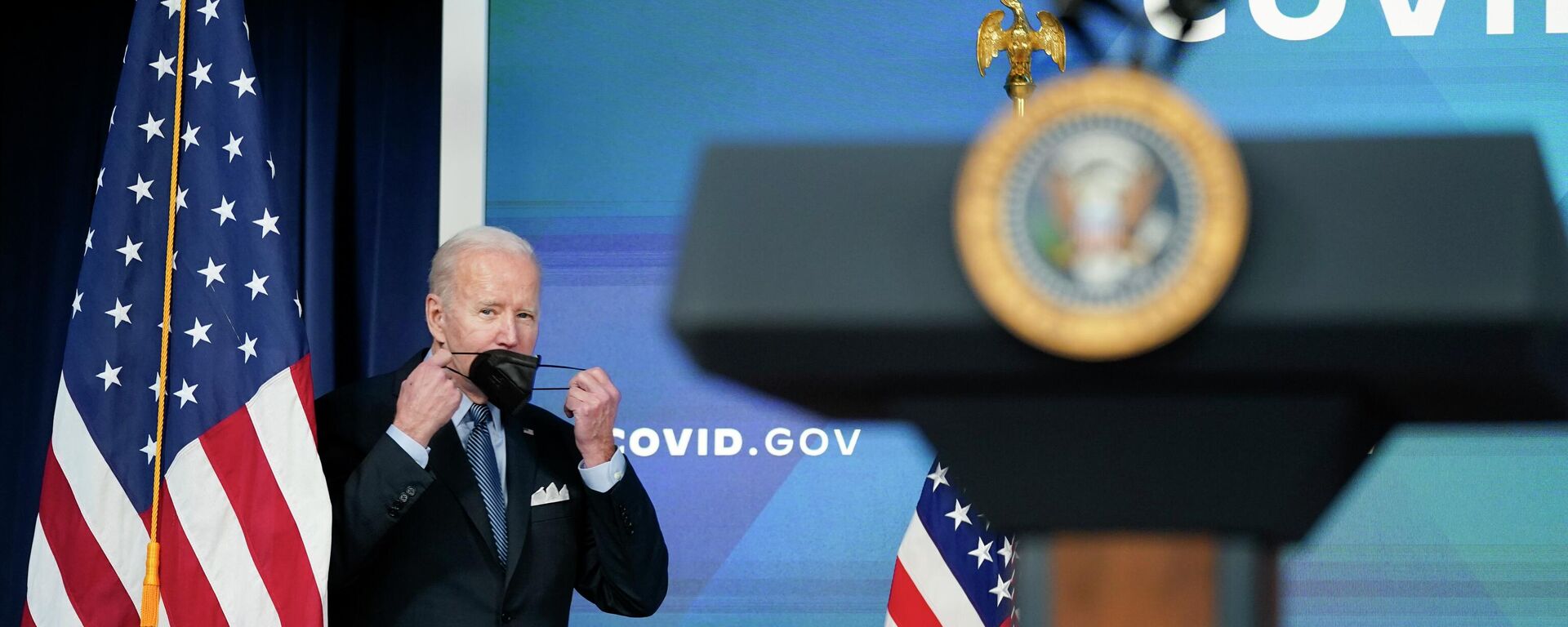 O presidente dos Estados Unidos, Joe Biden, segura sua máscara enquanto se aproxima do púlpito para discursar sobre os esforços do governo no combate à pandemia de COVID-19, em Washington, 30 de março de 2022 - Sputnik Brasil, 1920, 12.05.2022