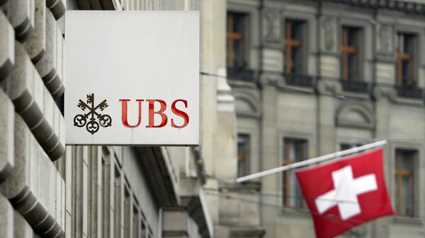 A bandeira suíça é vista atrás da logo do gigante bancário suíço UBS em Basileia, 11 de junho de 2013 - Sputnik Brasil