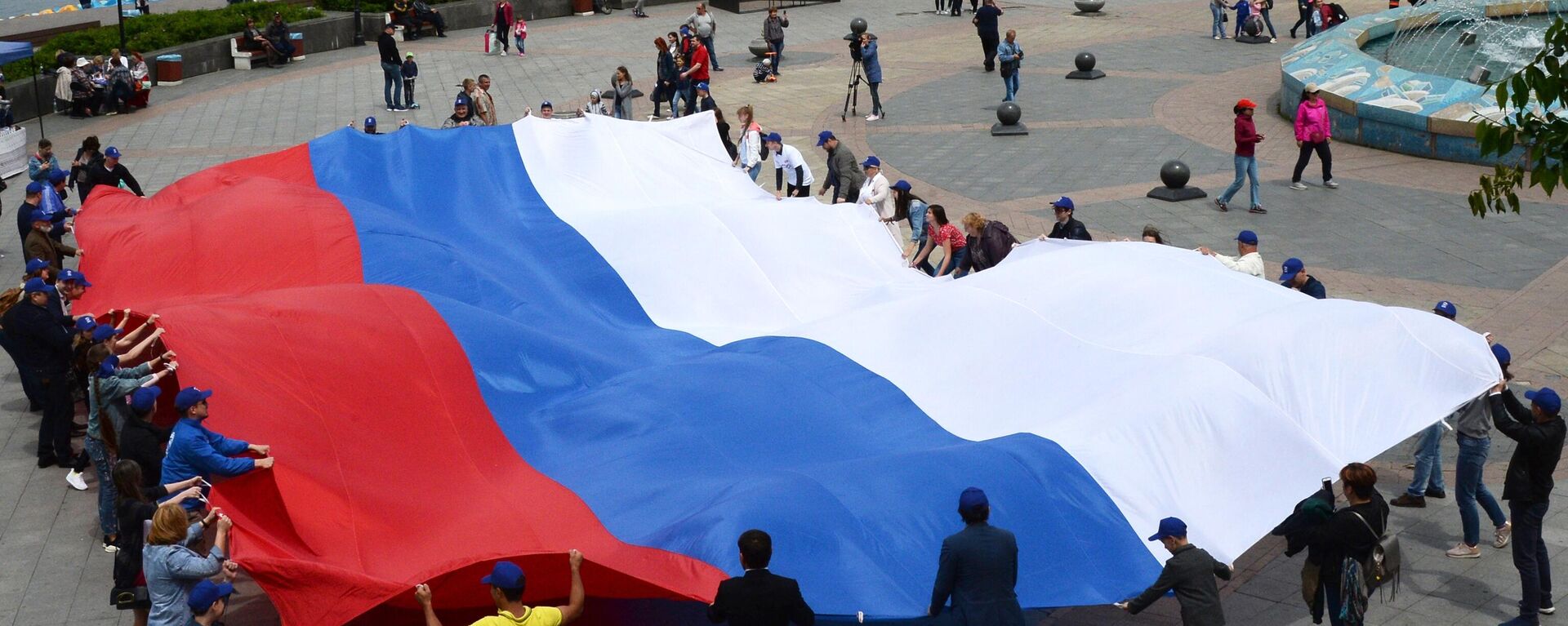 Pessoas seguram bandeira russa em Vladivostok, 12 de junho de 2018 - Sputnik Brasil, 1920, 19.05.2022