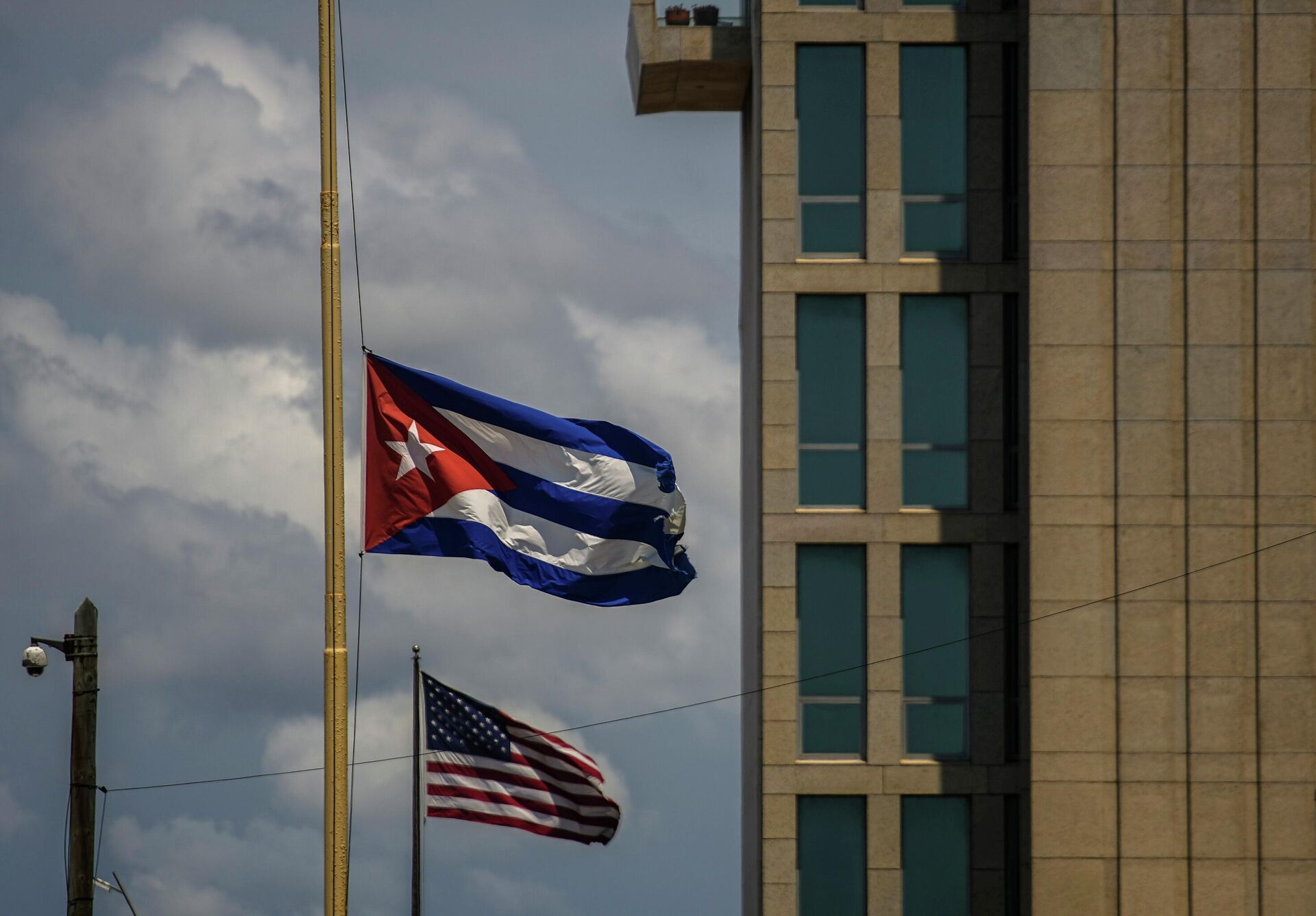 Uma bandeira cubana é vista ao lado de uma bandeira americana do lado de fora da embaixada dos EUA em Havana, Cuba, terça-feira, 17 de maio de 2022 - Sputnik Brasil, 1920, 16.06.2022