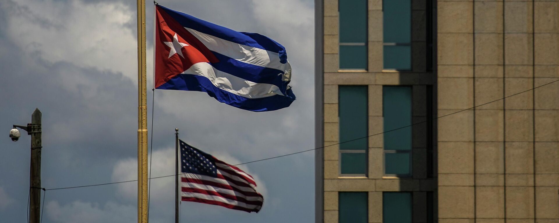 Uma bandeira cubana é vista ao lado de uma bandeira americana perto da embaixada dos EUA em Havana, em Cuba, em 17 de maio de 2022 (foto de arquivo) - Sputnik Brasil, 1920, 09.07.2022