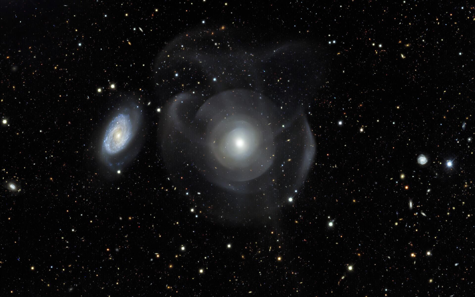 Galáxias elípticas como a NGC 474 são geralmente caracterizadas por sua aparência relativamente lisa quando comparadas com galáxias espirais (à esquerda), com estruturas floculentas entrelaçadas com faixas de poeira e braços espirais - Sputnik Brasil, 1920, 21.05.2022