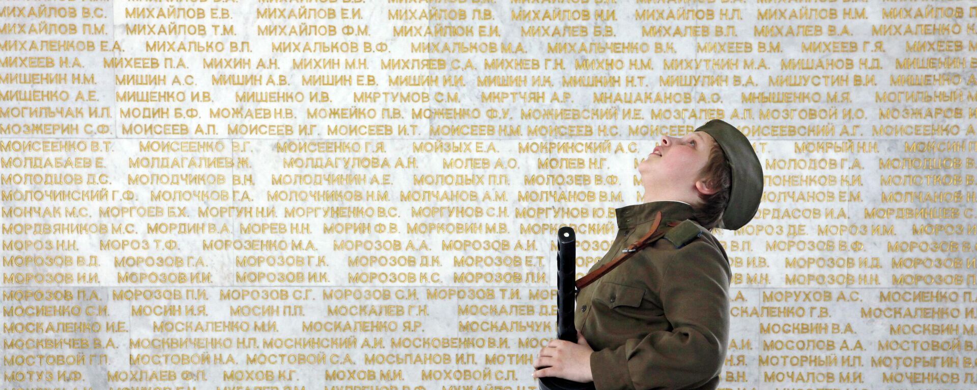 Garoto vestido com uniforme do Exército Vermelho em meio a milhares de nomes de soldados mortos na Grande Guerra pela Pátria, em um memorial dentro de um museu em Kiev, na Ucrânia, em 9 de maio de 2011 - Sputnik Brasil, 1920, 22.05.2022