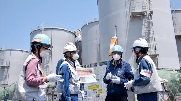O diretor-geral da Agência Internacional de Energia Atômica (AIEA), Rafael Grossi (2º à direita) em frente aos tanques de armazenamento de água radioativa em visita à usina nuclear da Tokyo Electric Power Company Holdings (TEPCO), Fukushima Daiichi em Okuma, prefeitura de Fukushima, 19 de maio de 2022 - Sputnik Brasil