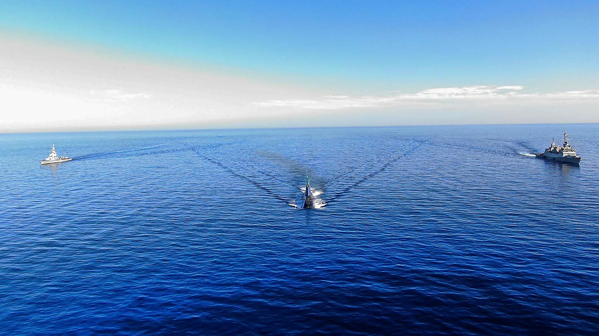 Esta imagem capturada de material divulgado pelas Forças de Defesa de Israel em 2 de junho de 2022 mostra o INS Tanin Dolphin Class Submarine, ao centro, cruzando as águas do mar Vermelho enquanto escoltado pelo INS Hanit Sa'ar-5, à direita, e INS Kidon Sa'ar-4.5,  2 de junho de 2022 - Sputnik Brasil, 1920, 02.06.2022
