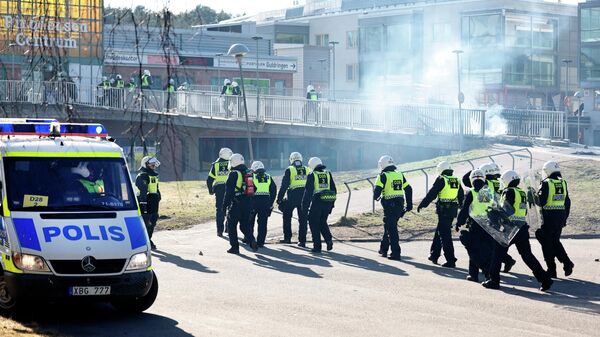 Polícia de choque passa por barricada para entrar em um centro comercial durante motim em Norrkoping, Suécia, 17 de abril de 2022 - Sputnik Brasil