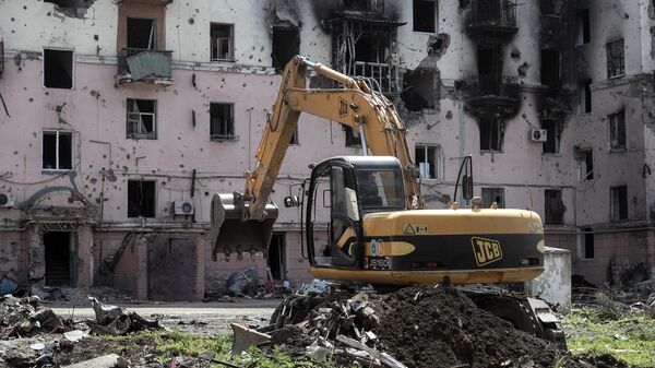 Escavadeira prepara local de sepultamento de civis mortos em Mariupol, em 6 de junho de 2022 - Sputnik Brasil
