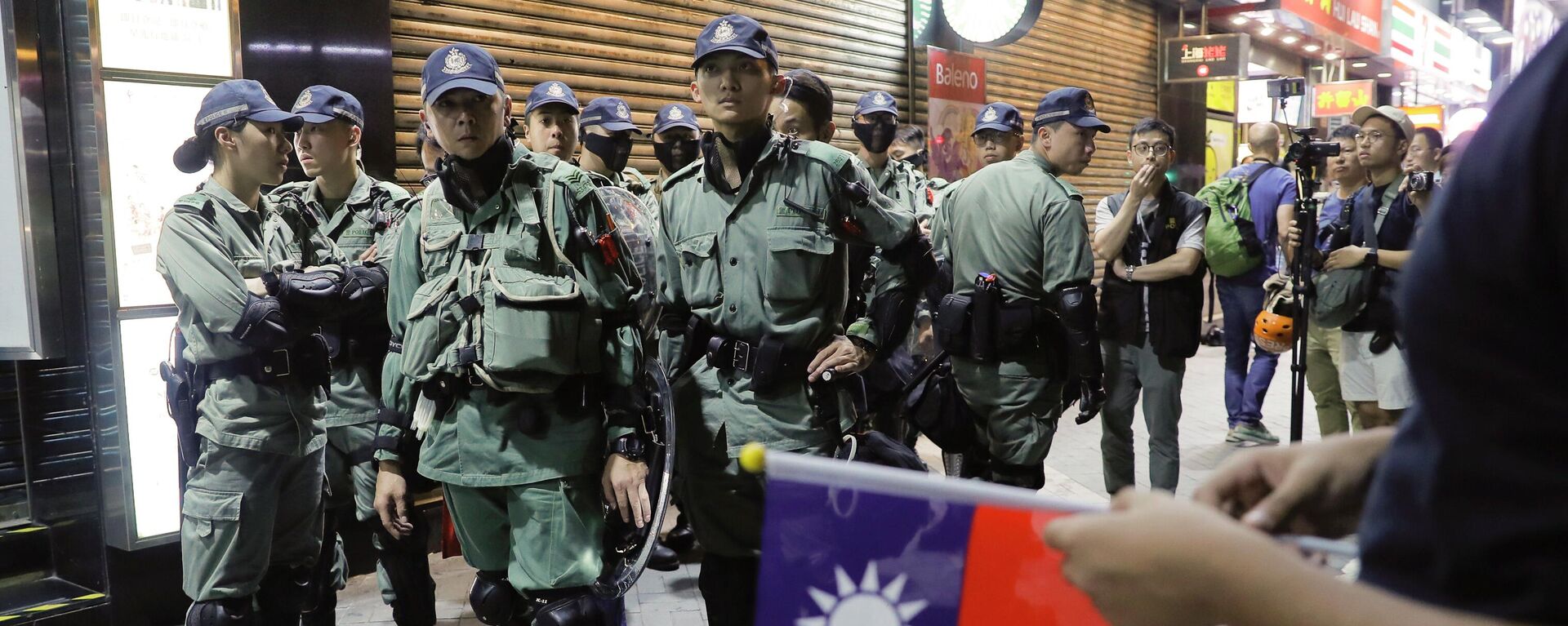 Polícia de choque olhando para pessoas segurando bandeiras de Taiwan enquanto se juntam a outras em uma manifestação para marcar o Dia Nacional de Taiwan - Sputnik Brasil, 1920, 14.06.2022