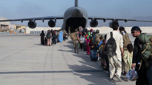 Membros da 816ª Esquadrilha Aérea Expedicionária da Força Aérea dos EUA carregam passageiros a bordo de um avião C-17 do ramo militar em meio à evacuação de civis no Aeroporto Internacional Hamid Karzai, Afeganistão, 24 de agosto de 2021 - Sputnik Brasil