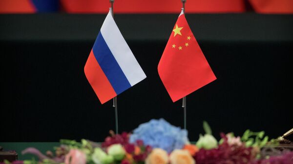 Bandeiras russa e chinesa em mesa antes de cerimônia de assinatura no Grande Salão do Povo, em Pequim (foto de arquivo) - Sputnik Brasil