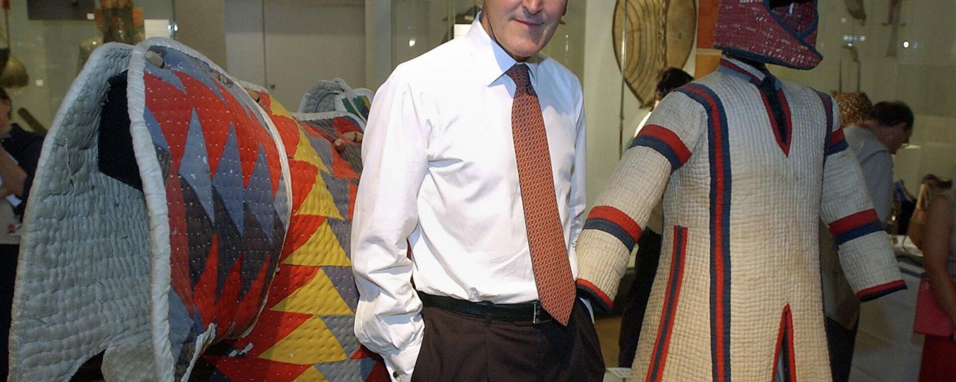 Neil McGregor, então diretor do Museu Britânico, em Londres, ao lado de um casaco acolchoado e um capacete de um cavaleiro do Sudão, em 12 de agosto de 2004 - Sputnik Brasil, 1920, 20.06.2022