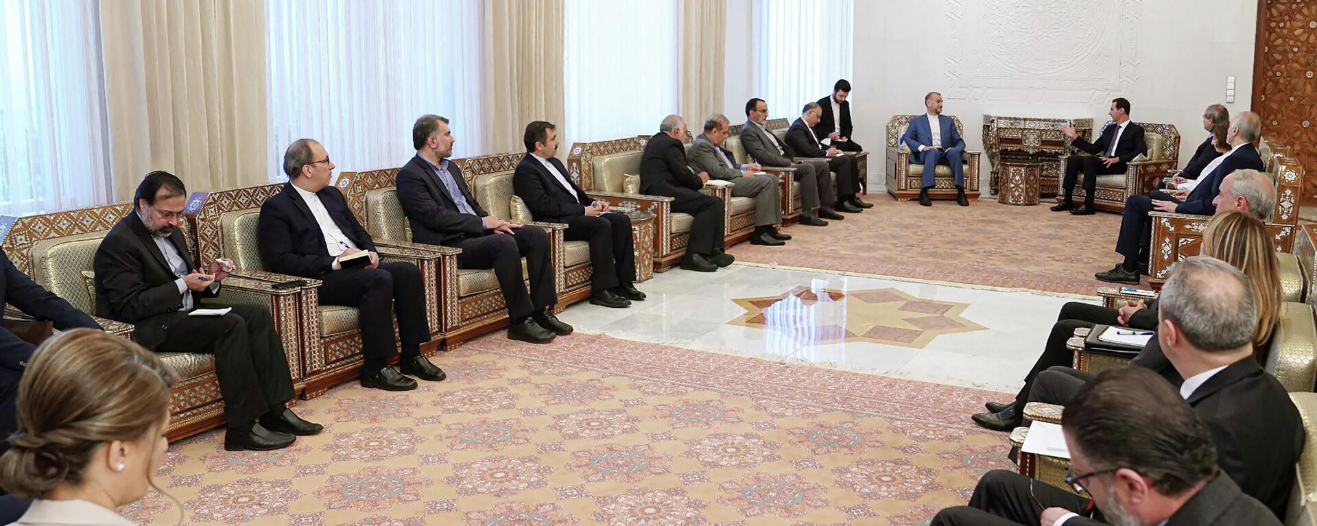 No fundo, Hossein Amirabdollahian, ministro das Relações Exteriores do Irã (à esquerda), falando com Bashar al-Assad, presidente da Síria, em Damasco, Síria, 2 de julho de 2022 - Sputnik Brasil, 1920, 03.07.2022