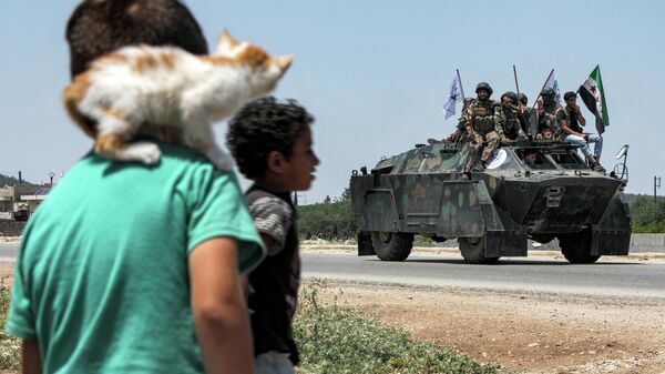 Garotos observam militares rebeldes sírios apoiados pela Turquia dentro de veículo blindado em estrada na província de Aleppo, Síria, 2 de julho de 2022 - Sputnik Brasil