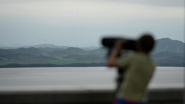 Visitante usa binóculos para ver o território fronteiriço da Coreia do Norte desde o observatório da unificação em Paju, Coreia do Sul, 7 de julho de 2022 - Sputnik Brasil