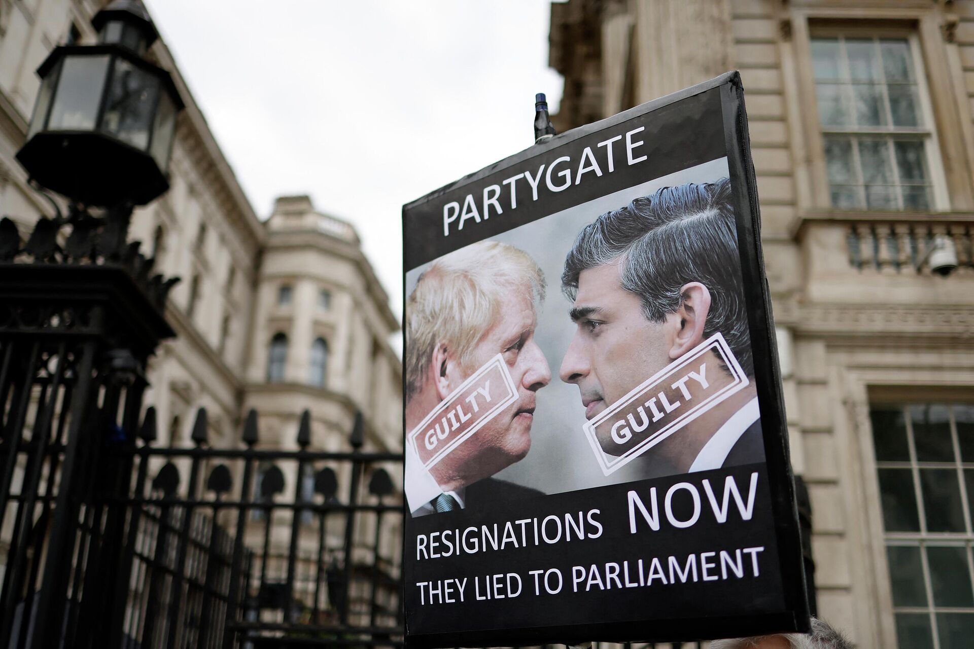 Manifestantes seguram cartazes pedindo a renúncia do primeiro-ministro e chanceler britânicos depois de serem multado por violarem as leis de bloqueio do COVID-19 no chamado escândalo Partygate, Londres, em 13 de abril de 2022 - Sputnik Brasil, 1920, 07.07.2022