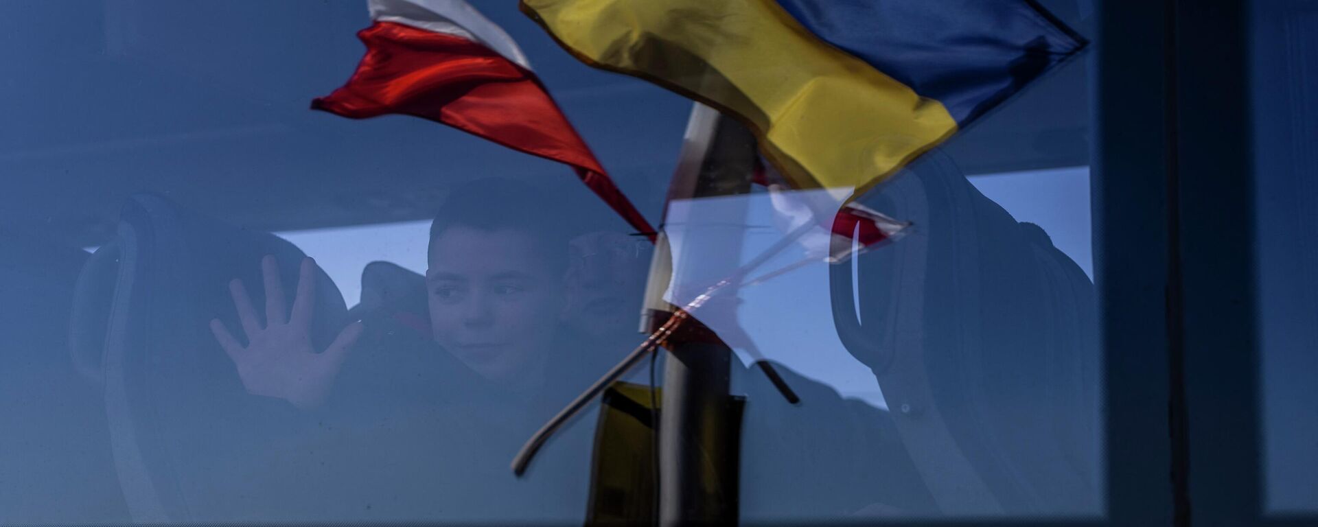 Bandeiras polonesa e ucraniana refletidas no vidro de ônibus cruzando da Ucrânia à Polônia no ponto fronteiriço de Medyka, 17 de março de 2022 - Sputnik Brasil, 1920, 12.07.2022