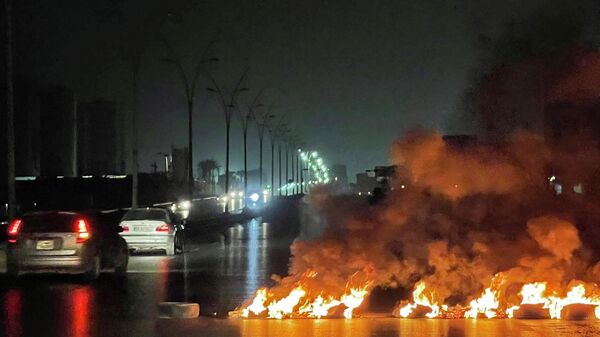 Foto tirada nas primeiras horas de 4 de julho de 2022 mostrando pneus queimando e bloqueando estradas durante protestos noturnos na capital líbia, Trípoli - Sputnik Brasil