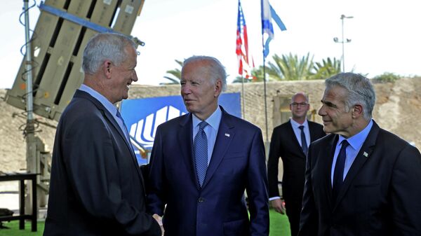 O presidente dos EUA, Joe Biden, ao centro, o primeiro-ministro interino israelense Yair Lapid, à direita, e o ministro da Defesa, Benny Gantz, em frente ao sistema de defesa Iron Dome de Israel durante uma excursão no Aeroporto Ben Gurion, perto de Tel Aviv, quarta-feira, 13 de julho de 2022 - Sputnik Brasil
