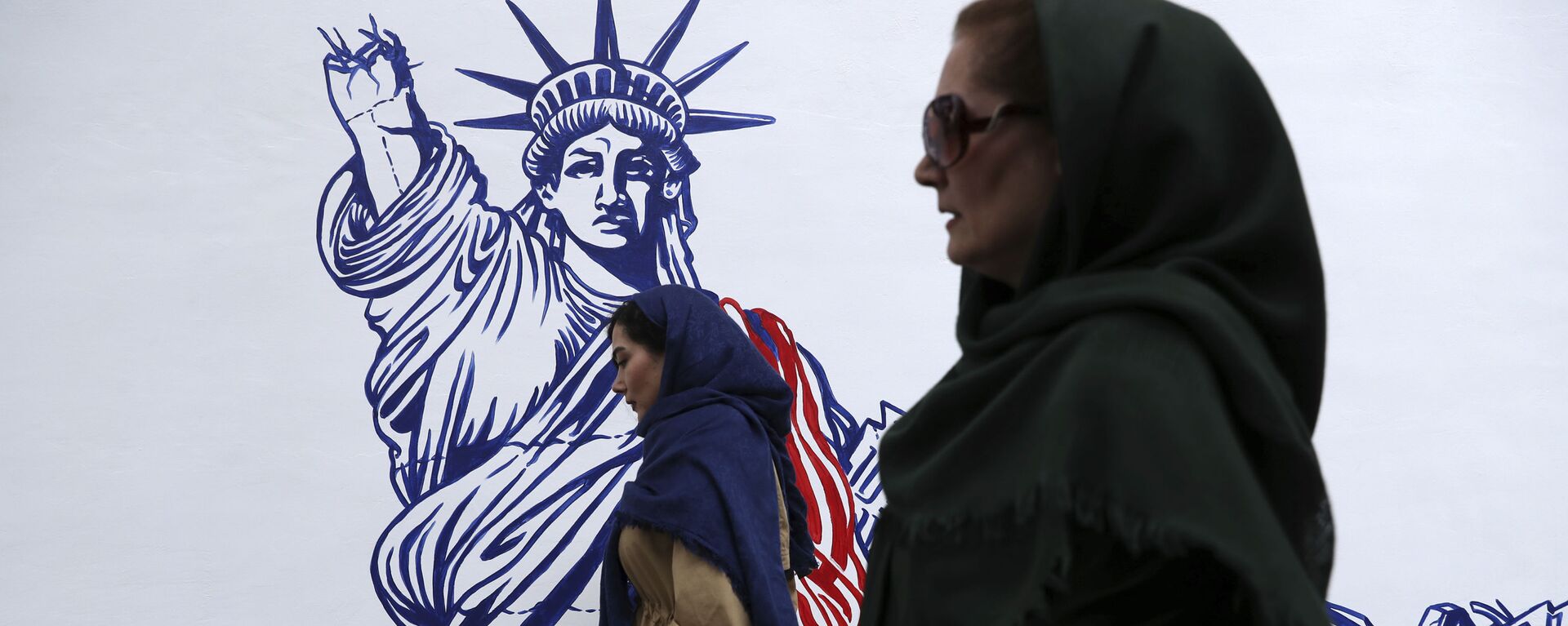Pessoas passam por mural satírico da Estátua da Liberdade no prédio da antiga embaixada da EUA em Teerã, Irã, 2 de novembro de 2019 - Sputnik Brasil, 1920, 09.08.2022
