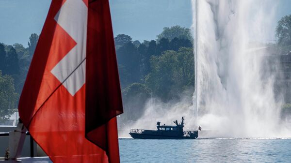 Um barco da polícia passa por uma bandeira suíça e uma fonte no Lago Genebra, em Genebra, Suíça, terça-feira, 15 de junho de 2021 - Sputnik Brasil
