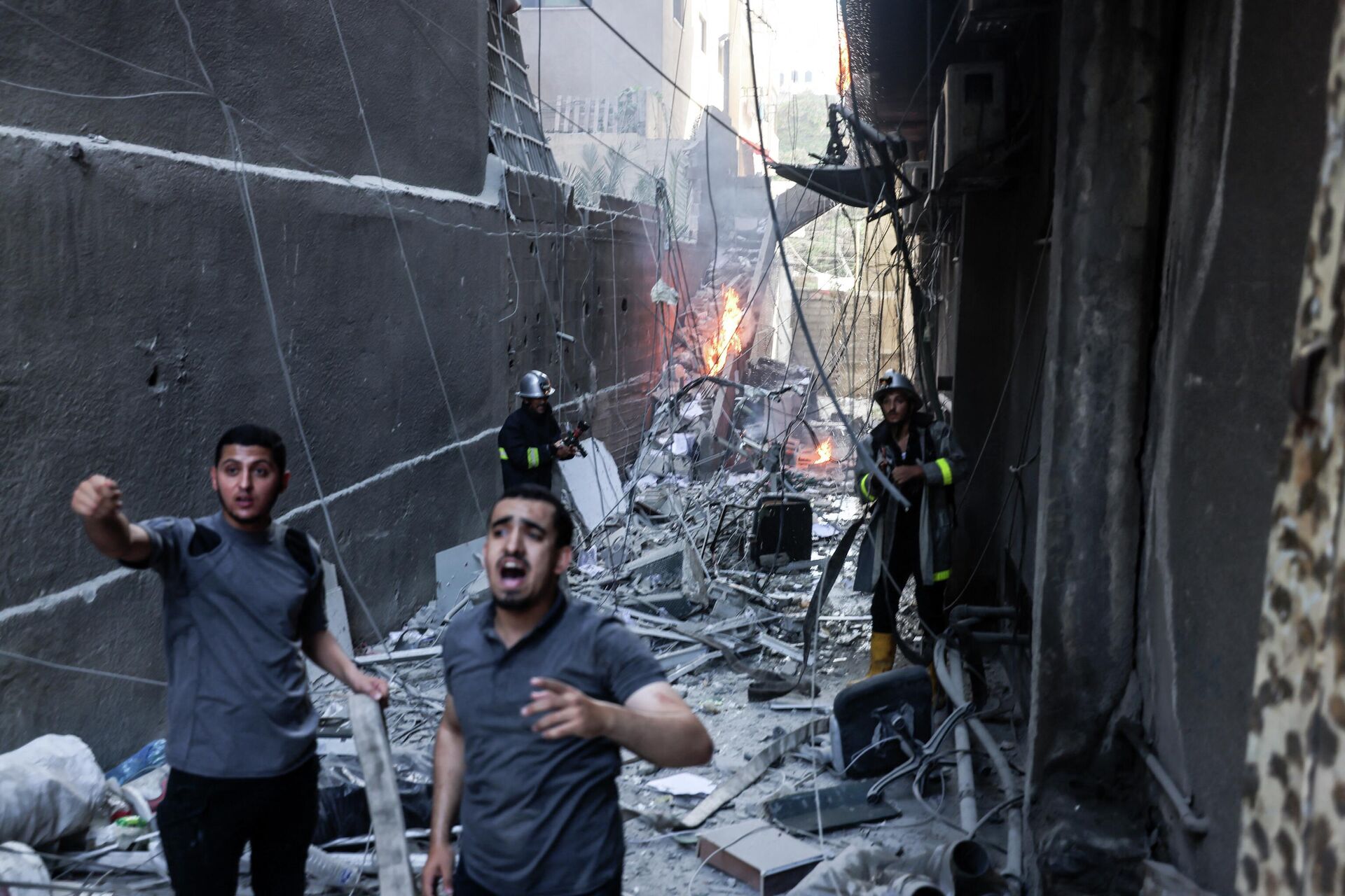 Equipes de resgate e bombeiros apagam incêndio em meio a destruição após ataque aéreo israelense em Gaza, em 5 de agosto de 2022 - Sputnik Brasil, 1920, 05.08.2022