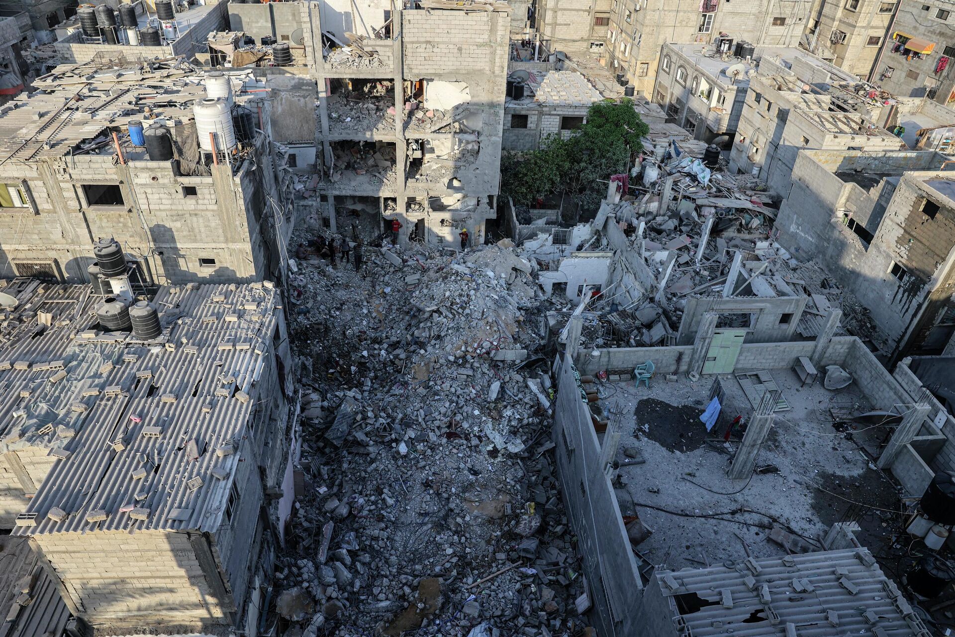 Palestinos procuram nos escombros de um edifício em que Khaled Mansour, um dos líderes da Jihad Islâmica na Palestina, morreu após ataque aéreo israelense, segundo o movimento, sul da Faixa Gaza, 7 de agosto de 2022 - Sputnik Brasil, 1920, 07.08.2022