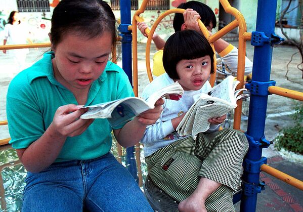 Nguyen Thuong Hai (à direita), de oito anos, está lendo uma revista em quadrinhos com seu amigo no balanço da Aldeia da Paz de Thanh Xuan, em Hanói, em 2000. Hai é um dos 100 garotos com deficiência mental e/ou física que vivem neste centro, que cuida principalmente das vítimas do agente laranja. - Sputnik Brasil