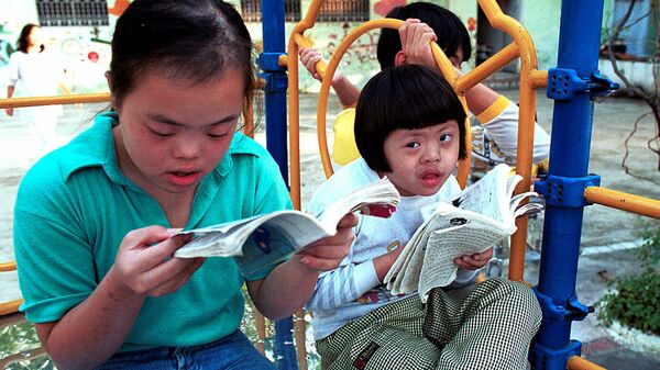 Nguyen Thuong Hai (à direita), de oito anos, está lendo uma revista em quadrinhos com seu amigo no balanço da Aldeia da Paz de Thanh Xuan, em Hanói, em 2000. Hai é um dos 100 garotos com deficiência mental e/ou física que vivem neste centro, que cuida principalmente das vítimas do agente laranja. - Sputnik Brasil
