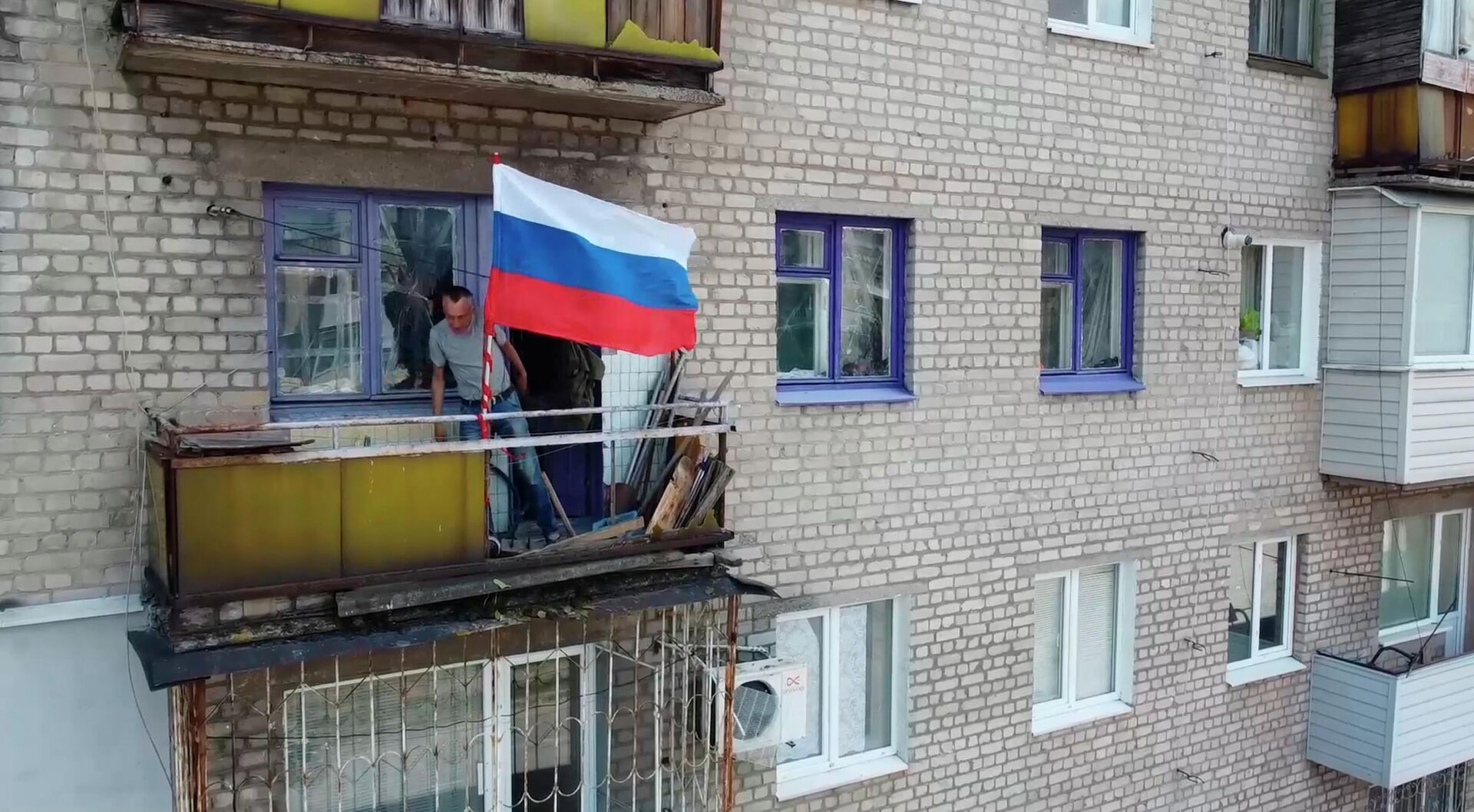Homem coloca bandeira russa na varanda de edifício residencial em Lisichansk, na República Popular de Lugansk (RPL), em 4 de julho de 2022 - Sputnik Brasil, 1920, 21.09.2022