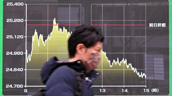 Um pedestre passa por um quadro eletrônico exibindo um gráfico dos movimentos diários do preço das ações na Bolsa de Valores de Tóquio, em Tóquio, em 8 de março de 2022 - Sputnik Brasil