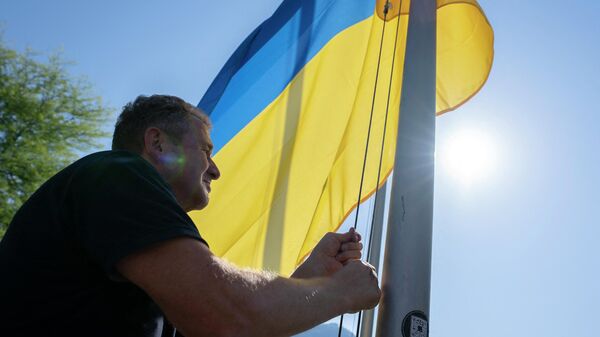 Homem segurando bandeira da Ucrânia em Lugano, Suíça, 3 de julho de 2022 - Sputnik Brasil