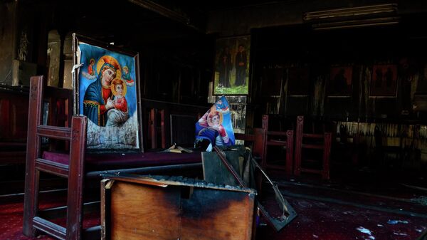 Móveis queimados, incluindo mesas e cadeiras de madeira, e imagens religiosas são vistos no local de um incêndio dentro da igreja copta que matou pelo menos 40 pessoas - Sputnik Brasil