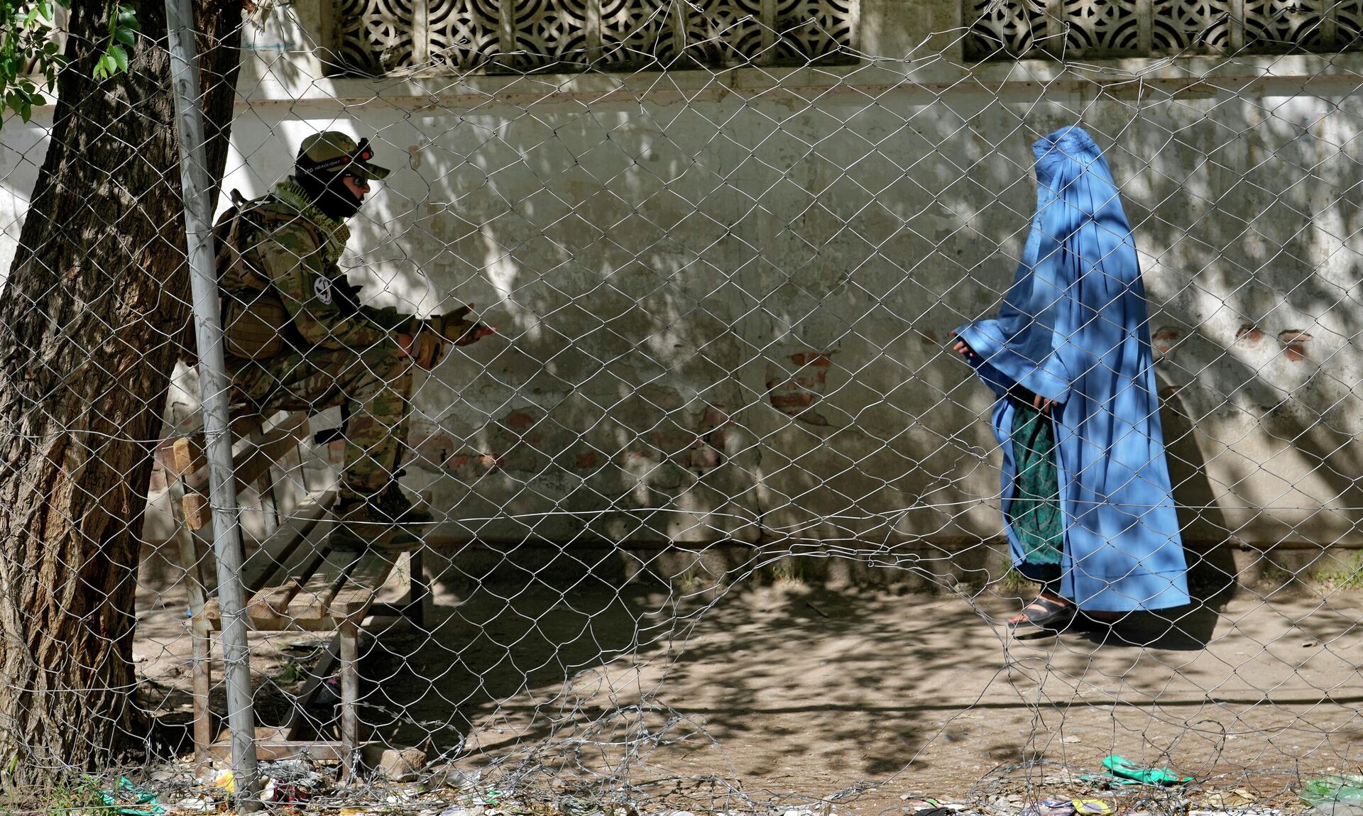 Talibã está de guarda enquanto mulher entra no escritório de passaportes do governo em Cabul, Afeganistão, 27 de abril de 2022 - Sputnik Brasil, 1920, 04.01.2023