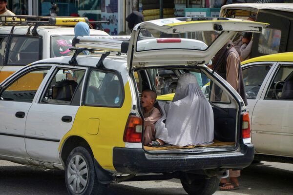Mulher com criança esperando na parte de trás de um taxi para se deslocar em Kandahar, 19 de julho de 2022. - Sputnik Brasil