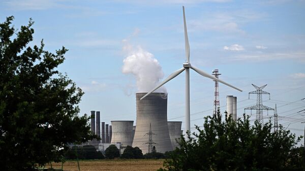 Turbina eólica é vista em frente a uma usina a carvão operada pela fornecedora de energia alemã RWE em Niederaussem, no oeste da Alemanha, em 13 de julho de 2022 (foto de arquivo) - Sputnik Brasil