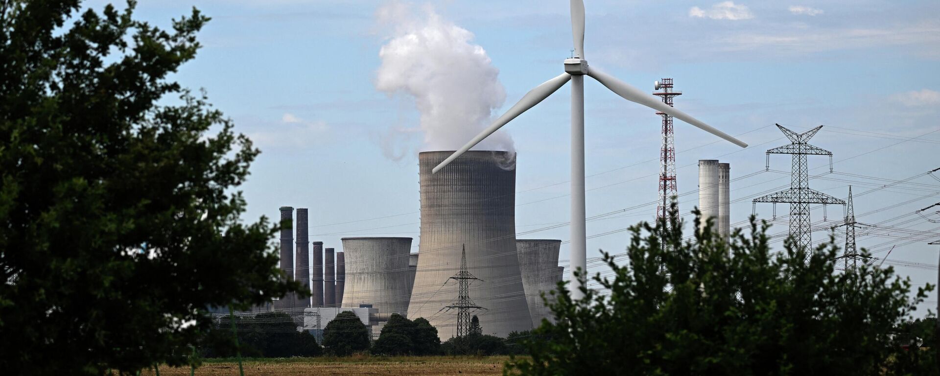 Turbina eólica é vista em frente a uma usina a carvão operada pela fornecedora de energia alemã RWE em Niederaussem, no oeste da Alemanha, em 13 de julho de 2022 (foto de arquivo) - Sputnik Brasil, 1920, 11.09.2022