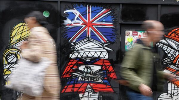 Compradores passam por graffiti em uma unidade de varejo fechada perto de Oxford Street, em Londres, 13 de abril de 2022 - Sputnik Brasil