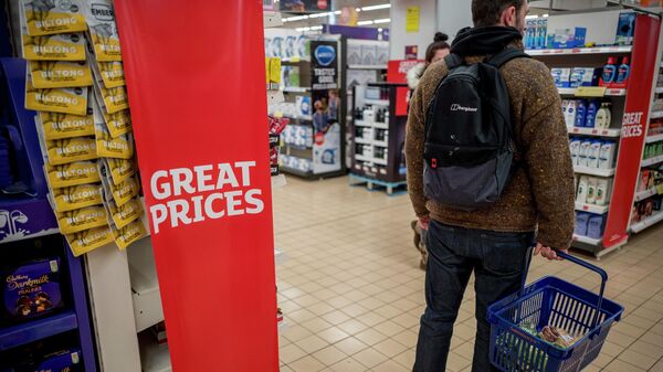 Um cliente carrega suas compras em uma cesta no supermercado Sainsbury's em Walthamstow, leste de Londres, 13 de fevereiro de 2022 - Sputnik Brasil