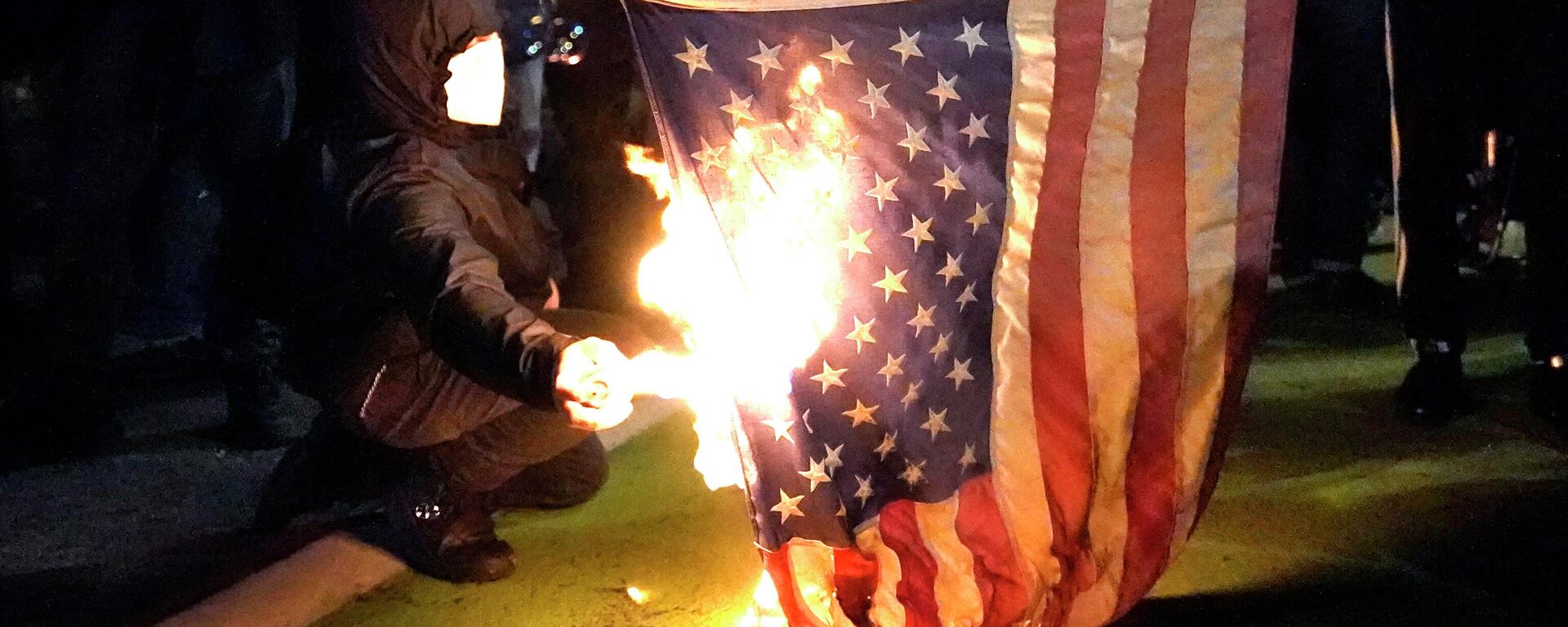 Manifestante põe fogo em bandeira americana durante protesto contra a desigualdade racial e a violência policial em Portland, Oregon, EUA, 27 de julho de 2020 (Foto de Arquivo) - Sputnik Brasil, 1920, 23.10.2023