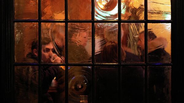 Um cliente bebe dentro de um bar em Londres, em 17 de dezembro de 2021 - Sputnik Brasil