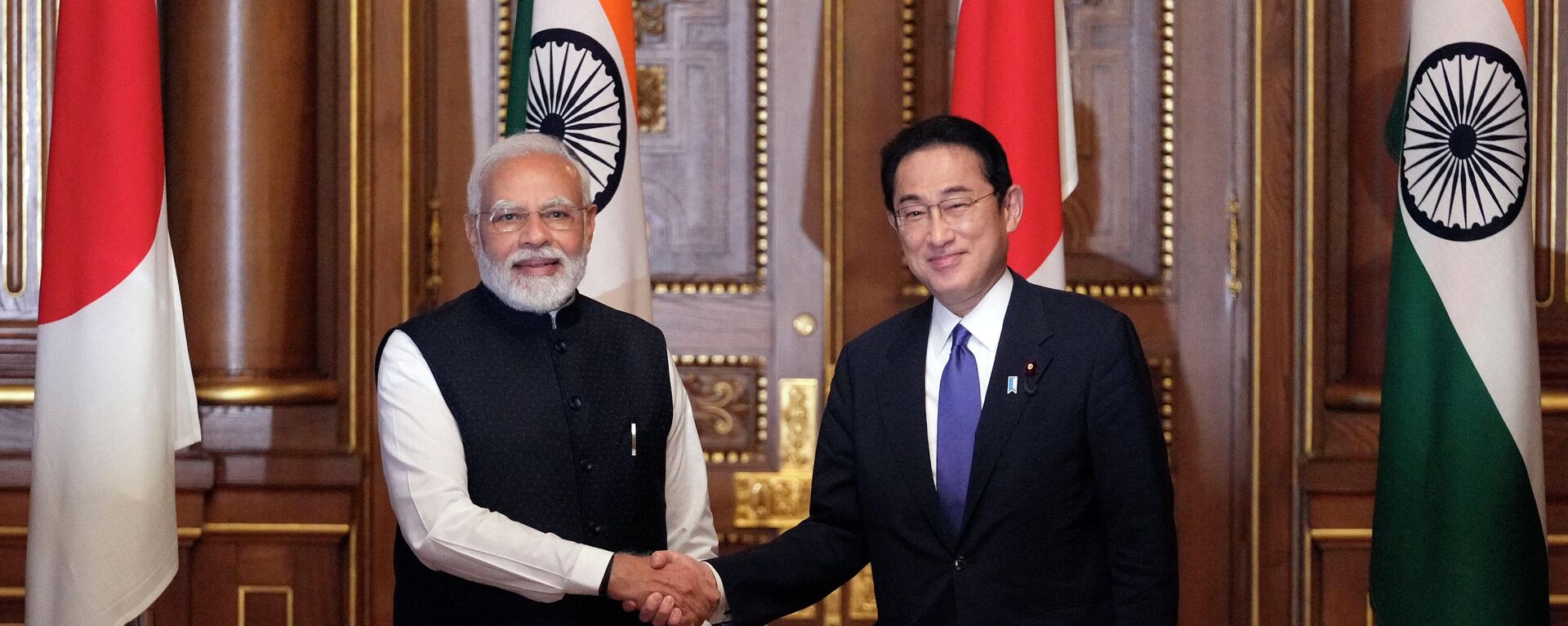 O primeiro-ministro da Índia, Narendra Modi (E) e o primeiro-ministro do Japão, Fumio Kishida, apertam as mãos no início da reunião de cúpula Japão-Índia, após o término da cúpula dos líderes do Quad entre os EUA, Japão, Índia e Austrália, no estado de Akasaka, Guest House em Tóquio, 24 de maio de 2022 - Sputnik Brasil, 1920, 25.08.2022