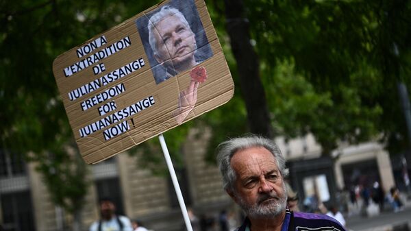 Apoiador segura cartaz protestando a extradição aos EUA de Julian Assange, denunciante do Wikileaks, Praça da República, Paris, França, 3 de julho de 2022 - Sputnik Brasil