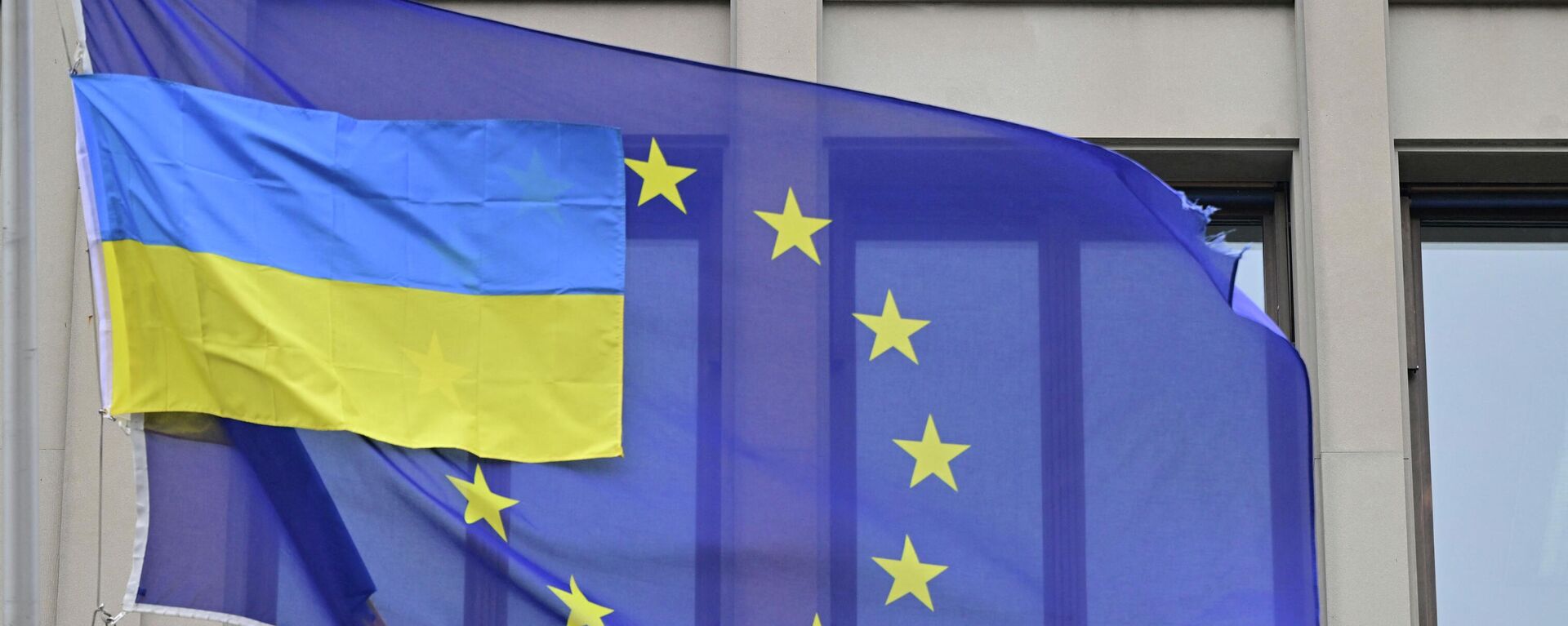 Bandeira ucraniana junto com a bandeira da União Europeia em frente à representação da UE em Berlim, Alemanha, 5 de abril de 2022 - Sputnik Brasil, 1920, 30.08.2022