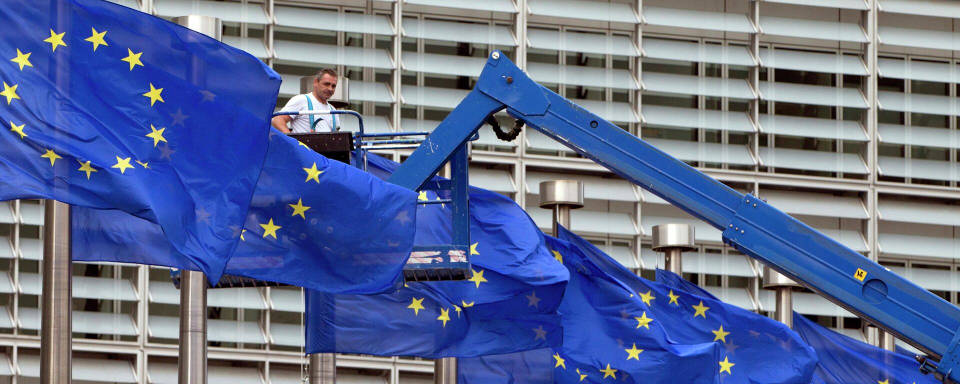 Nesta foto, um trabalhador em um elevador ajusta as bandeiras da União Europeia (UE) em frente à sede, em Bruxelas, 23 de junho de 2016 - Sputnik Brasil, 1920, 14.09.2022
