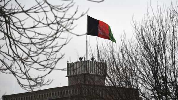 Pessoal de segurança afegão vigia uma torre enquanto a bandeira nacional afegã tremula antes do início da cerimônia de posse do presidente Ashraf Ghani, no Palácio Presidencial em Cabul, 9 de março de 2020 - Sputnik Brasil
