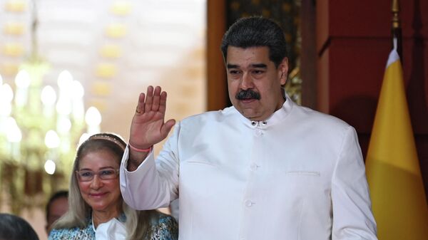 Nicolás Maduro, presidente venezuelano, acompanhado por sua esposa Cilia Flores, se despede de Armando Benedetti, embaixador da Colômbia na Venezuela (fora da foto), no Palácio Presidencial de Miraflores, Caracas, Venezuela - Sputnik Brasil