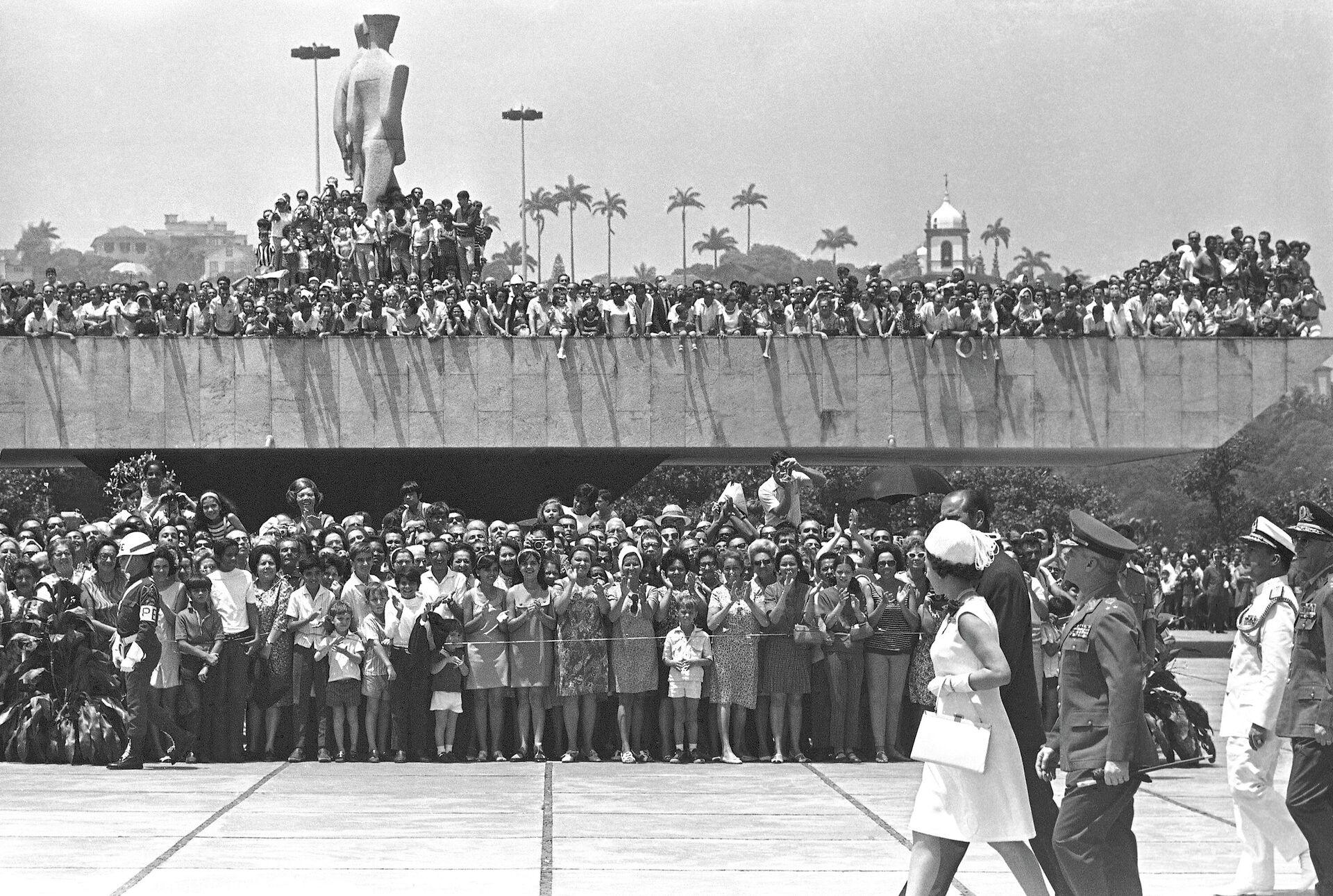 A rainha britânica Elizabeth II, usando um vestido branco com chapéu combinando, acena para a multidão enquanto caminha em direção ao Memorial de Guerra no Rio de Janeiro, Brasil, em 10 de novembro de 1968 - Sputnik Brasil, 1920, 08.09.2022